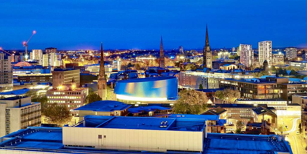 View of Coventry City Centre from One Friargate, Friargate Boulevard, Coventry, England, United Kingdom (October 2019) showing the three spires of the city plus The Wave waterpark.