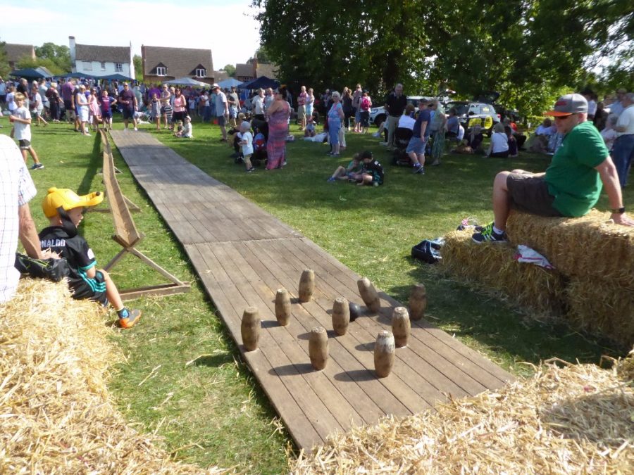 People playing skittles at a village fete.